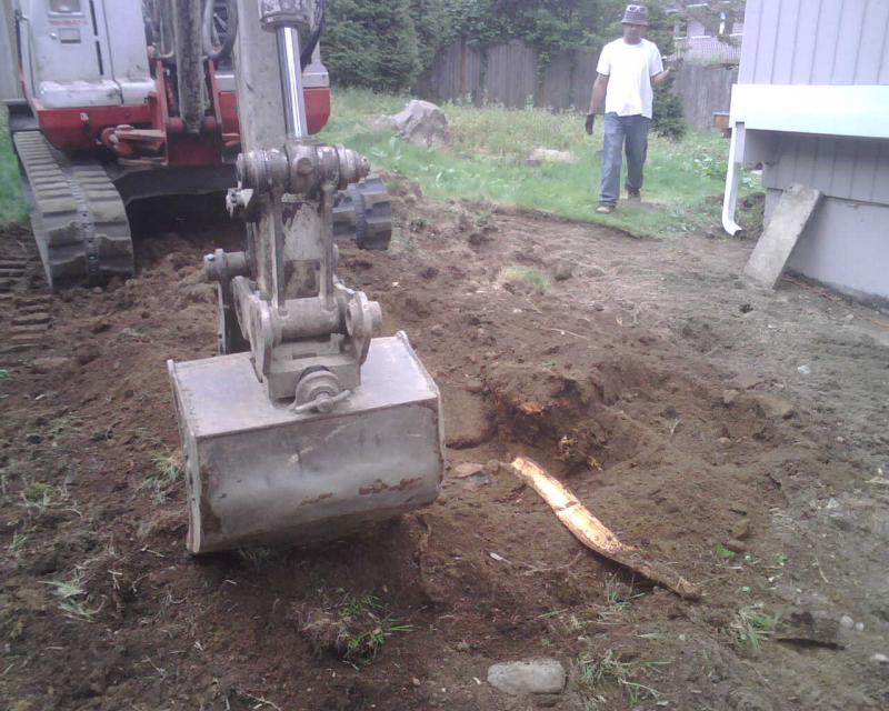 Our excavator breaking ground for a garage footing in Seattle.