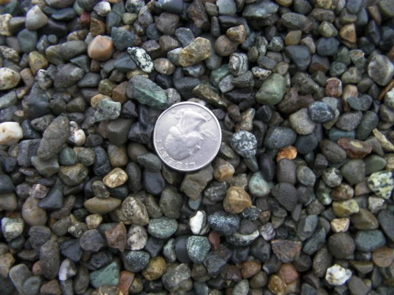Pea gravel or 3/8th washed round drain rock.  Used for pathways too.
